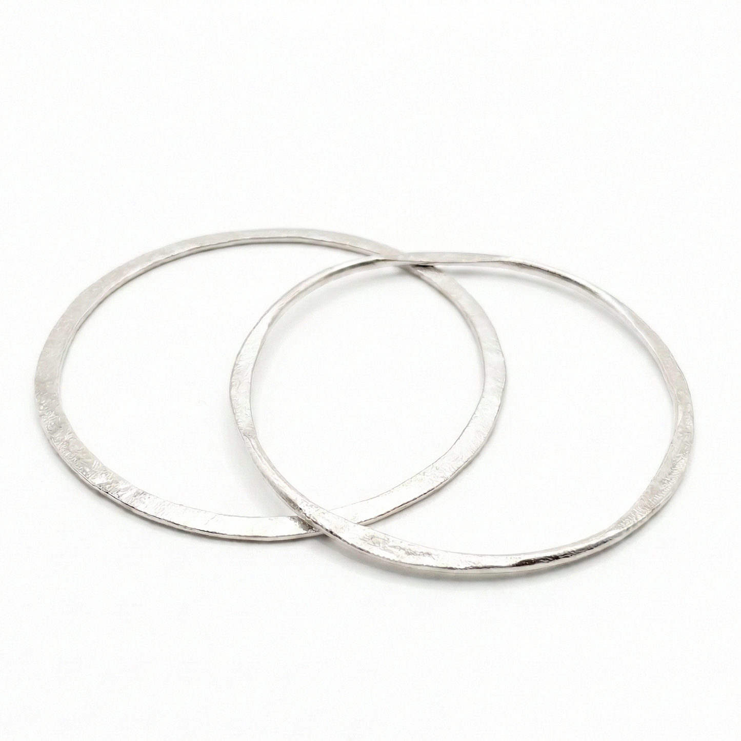 Two silver bangles earrings on a white background