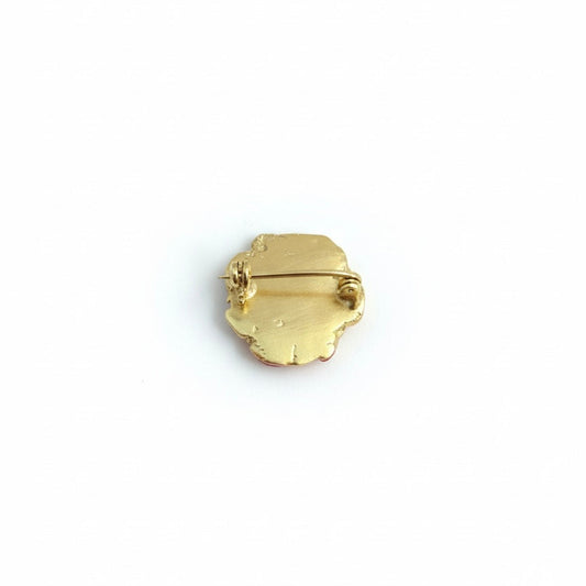 Gold-plated brooch on a white background