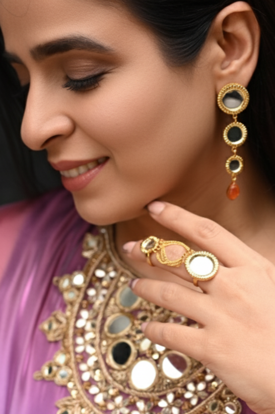 Woman wearing traditional jewelry including earrings, necklace, and ring, with a blurred background