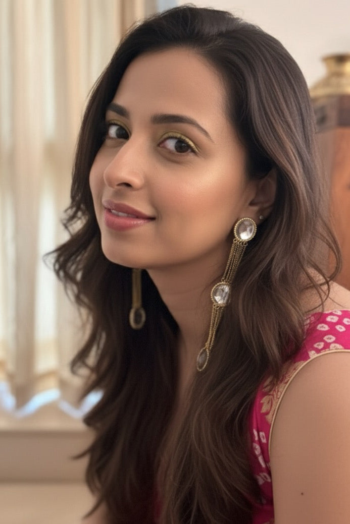 Woman with long brown hair wearing earrings indoors