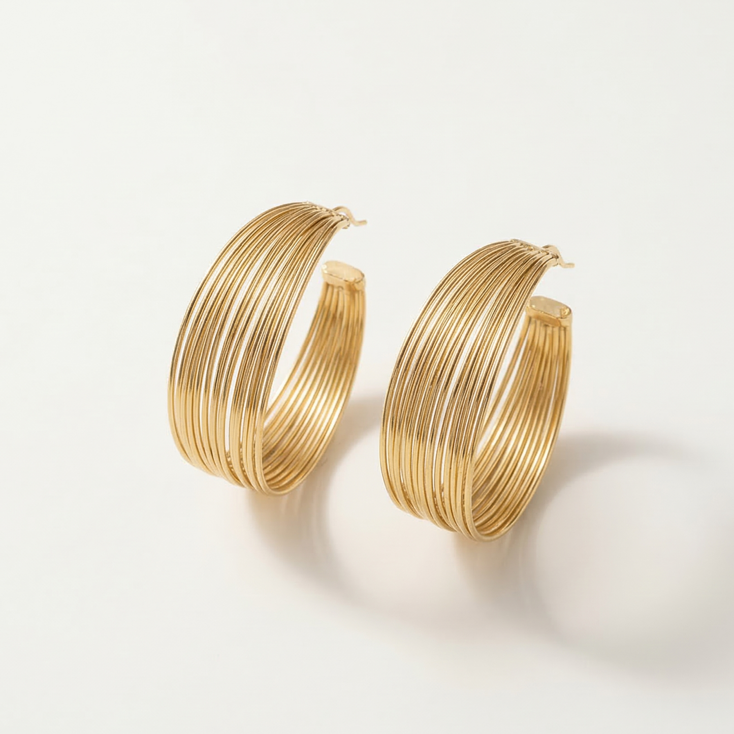 Gold hoop earrings on a light beige background
