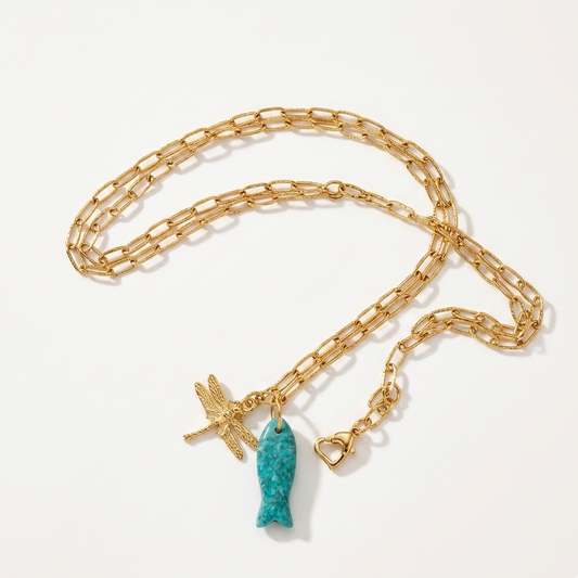Gold chain necklace with two charms on a white background