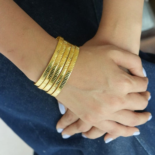Close-up of hands with gold bracelets on a blurred background