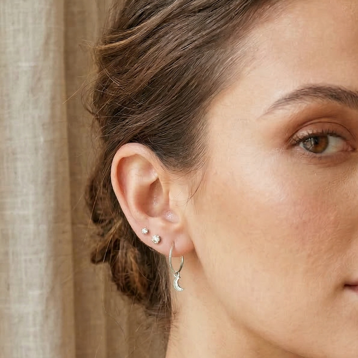Woman with styled hair and earrings in an indoor setting
