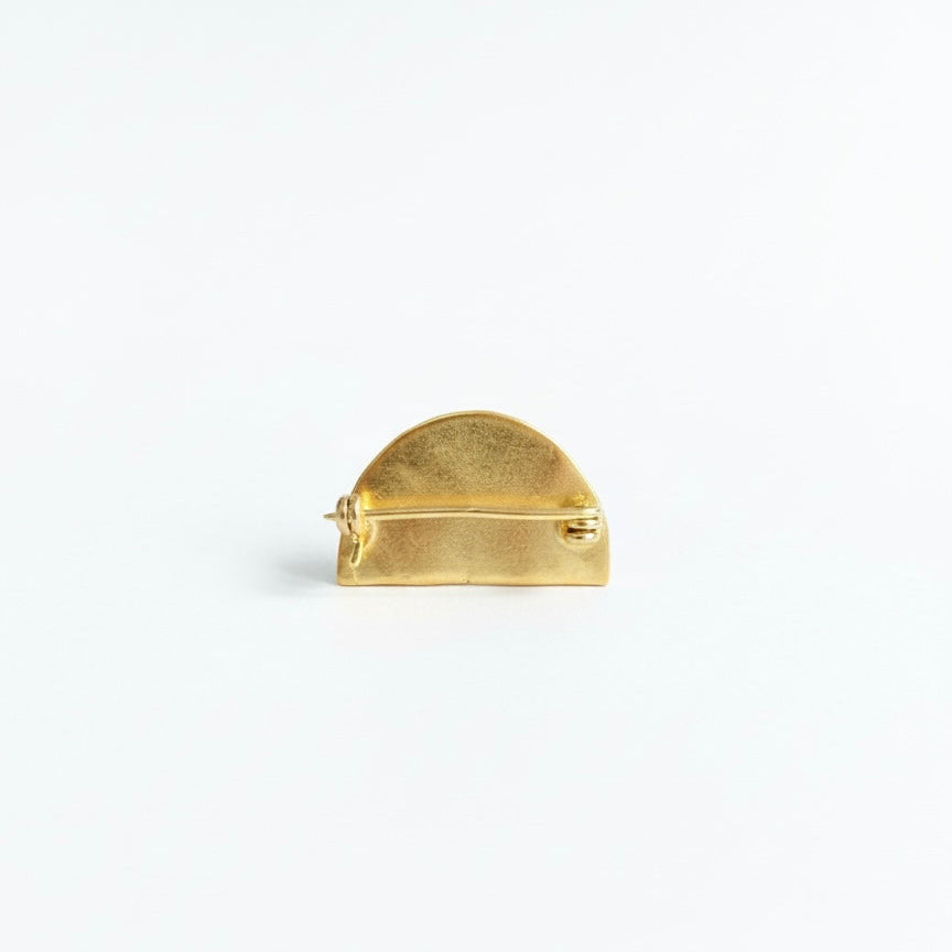 Gold brooch on a white background