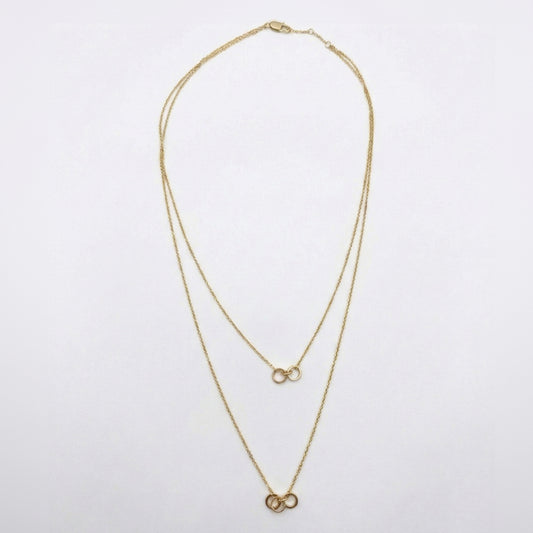 Gold necklace with two interlocking rings on a white background