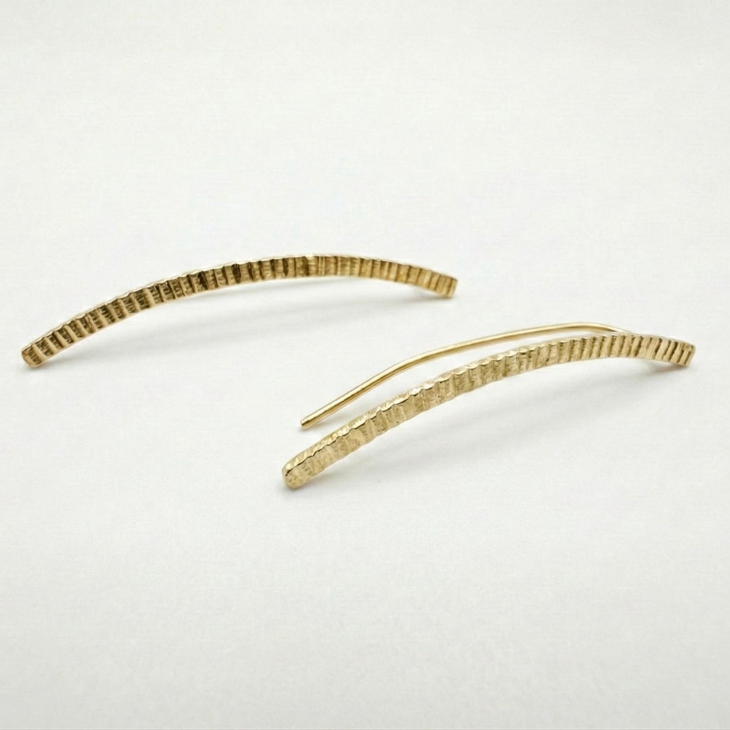 Gold lined earclimbers on a light gray background