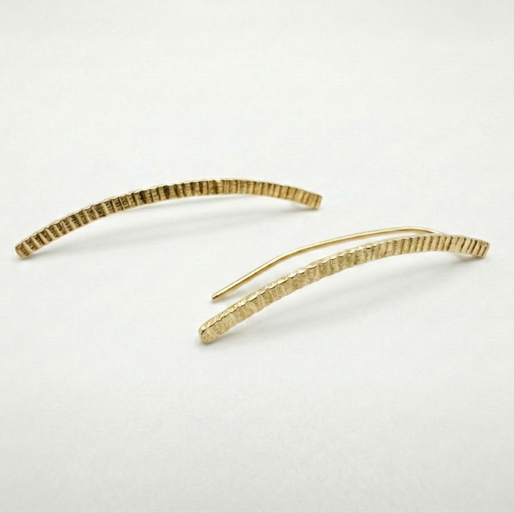 Gold lined earclimbers on a light gray background