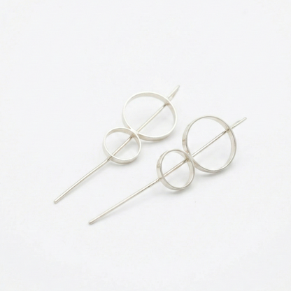 8 stick hoop earrings circular designs on a white background
