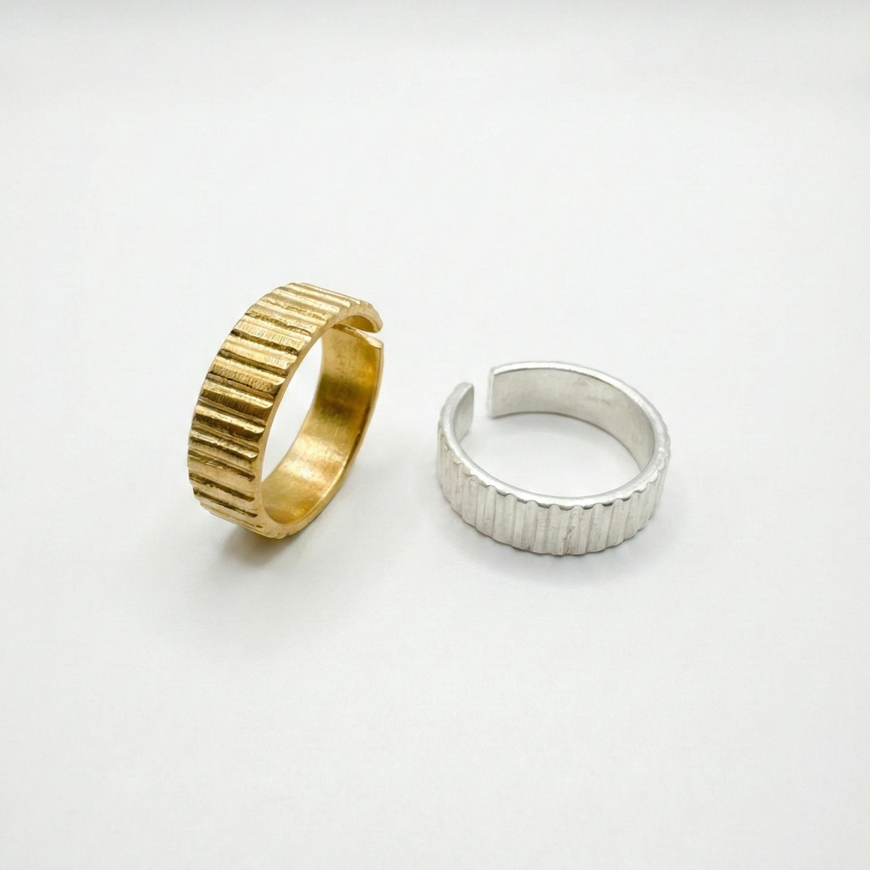Gold and silver ribbed rings on a white background