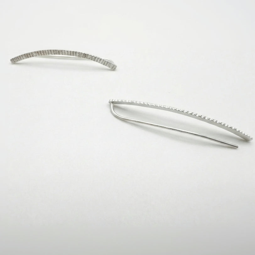 Silver earclimbers on a white background