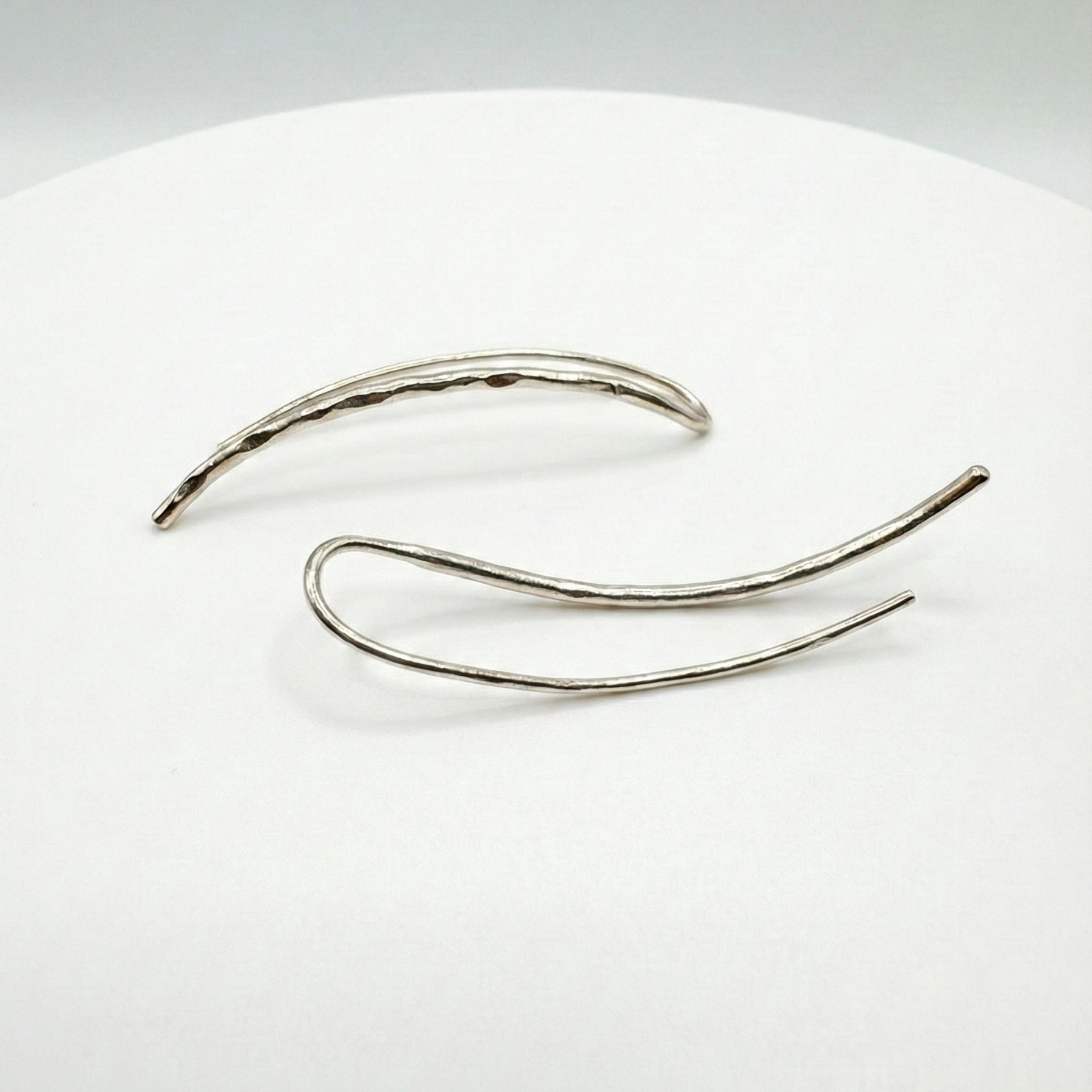 Silver earclimbers on a white background