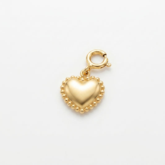 A polished gold heart charm with a beaded border and a spring-ring clasp, shown on a clean white background.