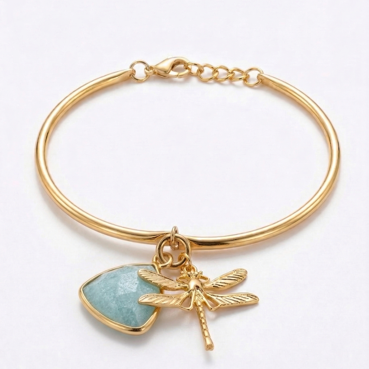 Gold bracelet with a dragonfly and aquamarine stone charm on a white background
