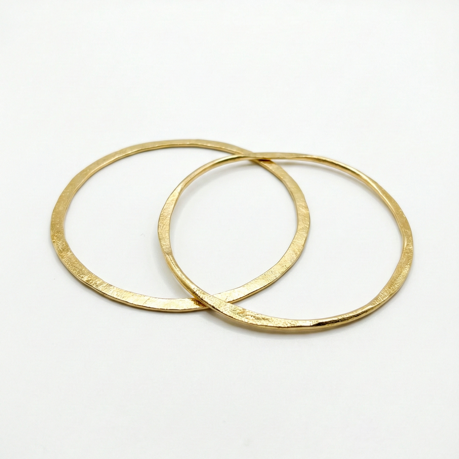 Two gold bangles on a white background