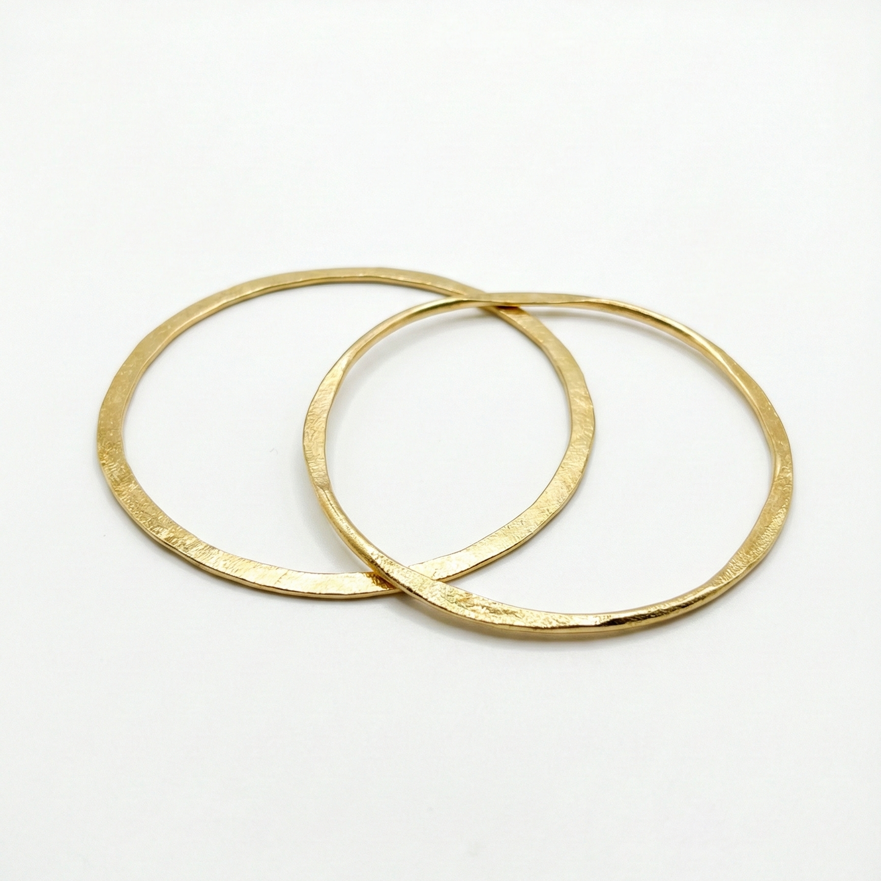 Two gold bangles on a white background