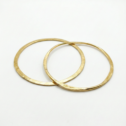 Two gold bangles on a white background
