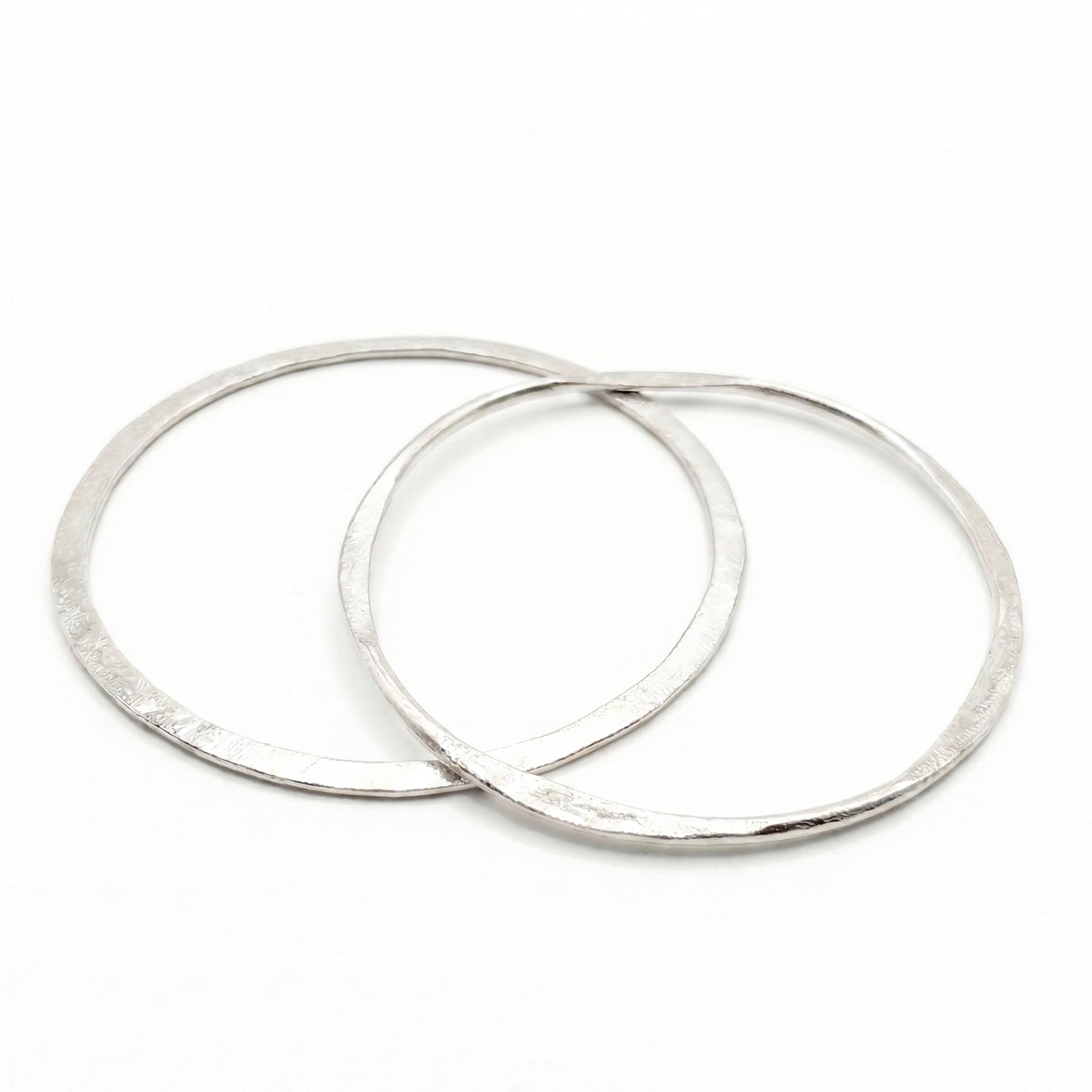 Two silver bangles earrings on a white background