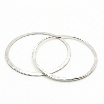 Two silver bangles earrings on a white background