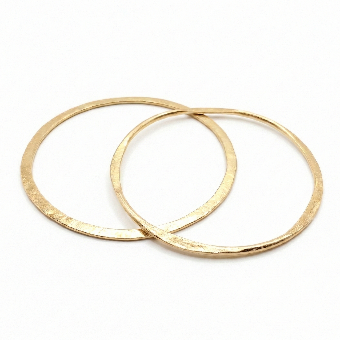 Two gold bangles on a white background