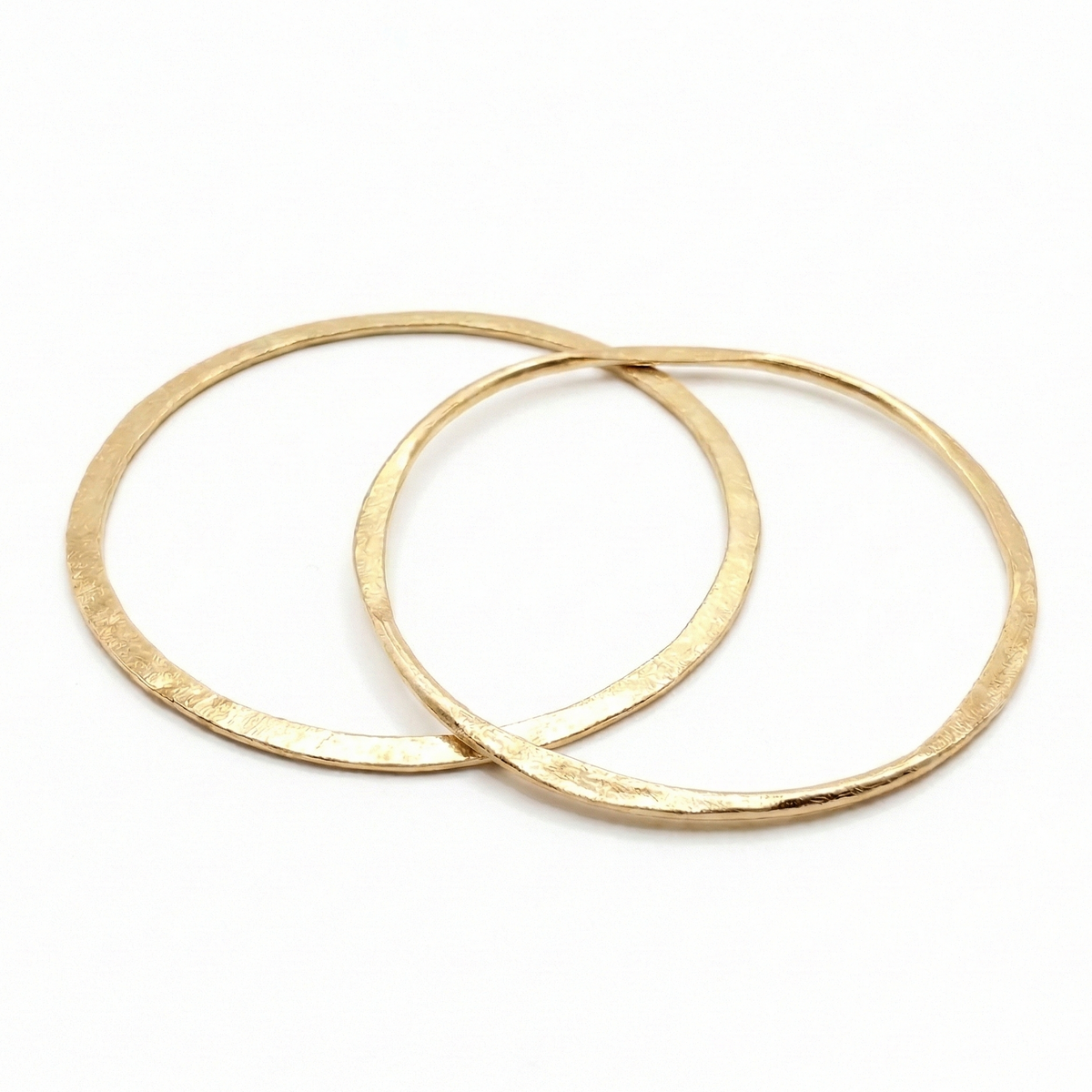 Two gold bangles on a white background
