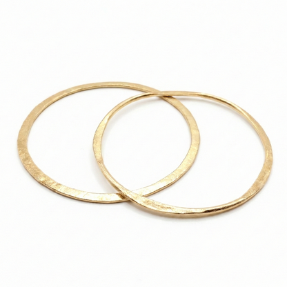 Two gold bangles on a white background
