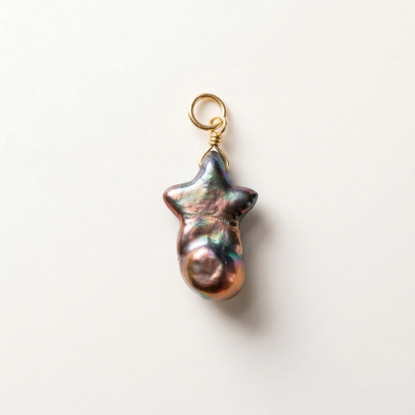 Pearl charm with gold clasp on a white background