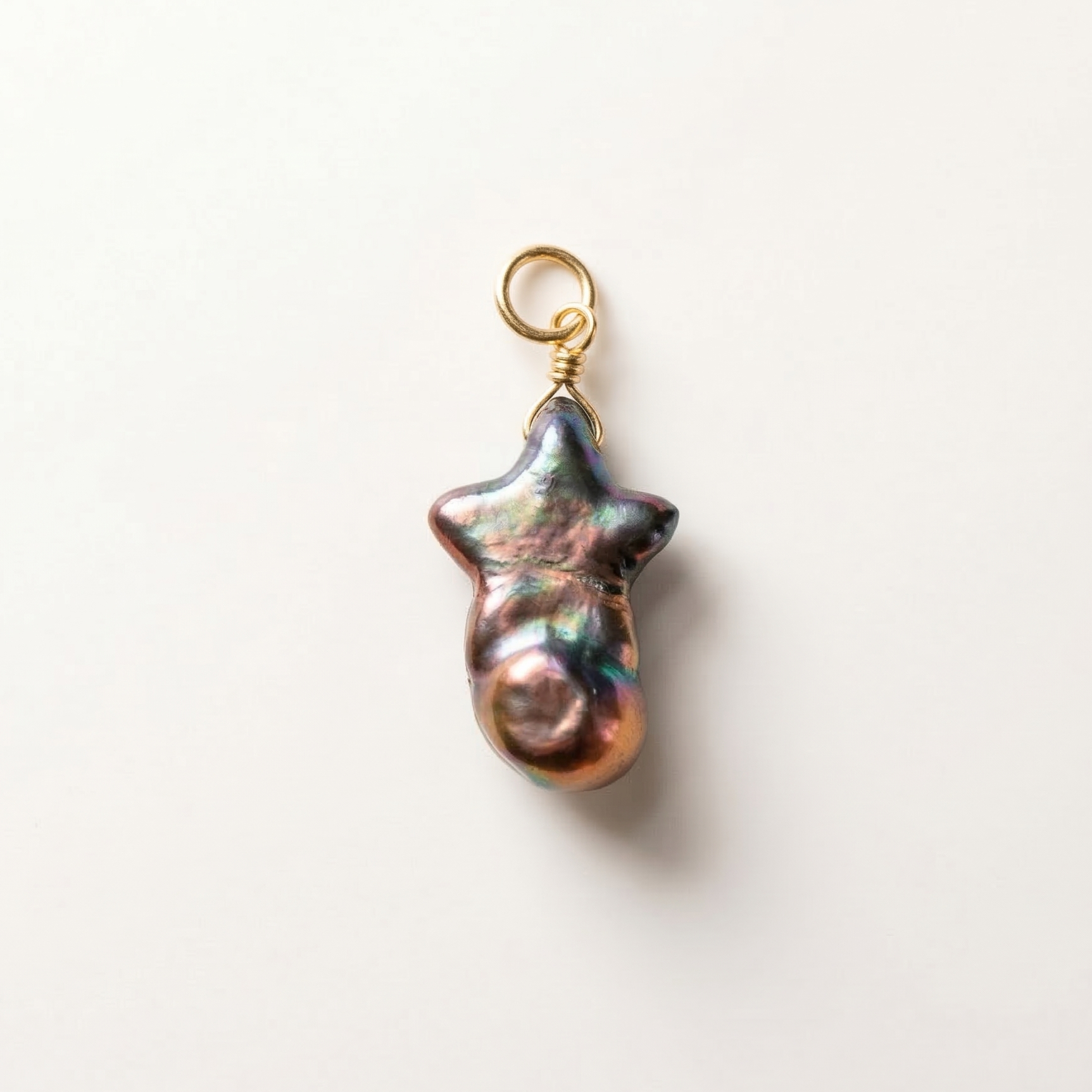 Pearl charm with gold clasp on a white background