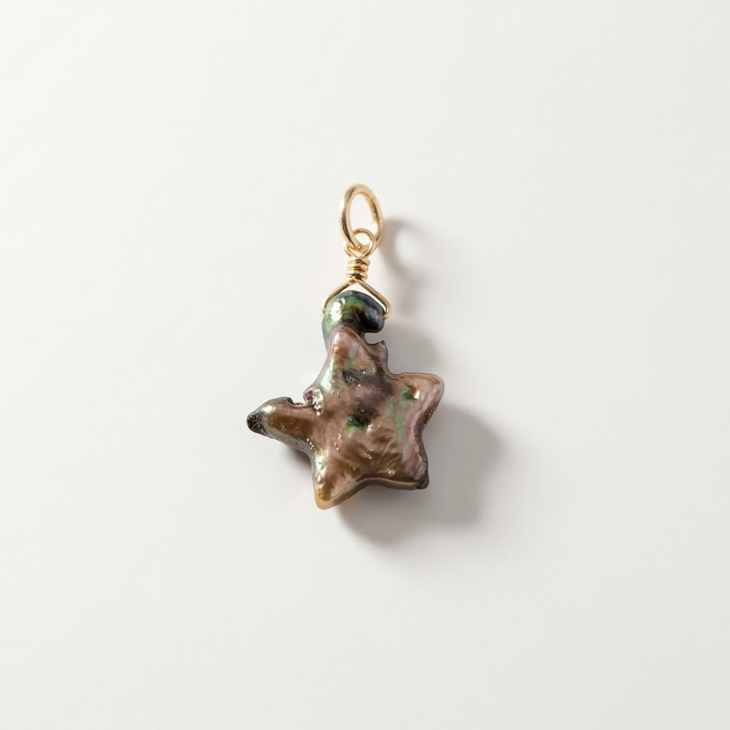 Star-shaped pearl pendant with a gold chain on a white background