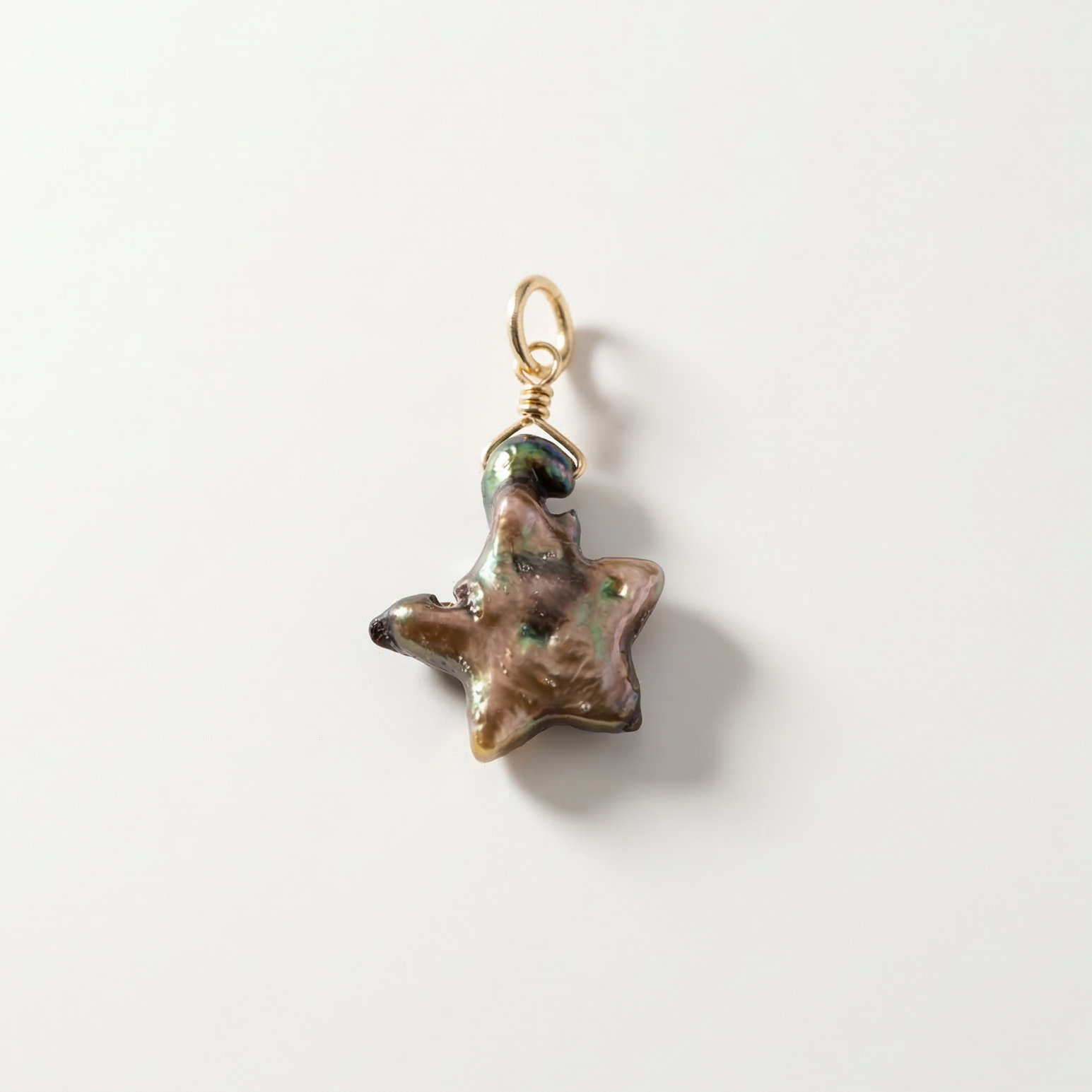 Star-shaped pearl pendant with a gold chain on a white background