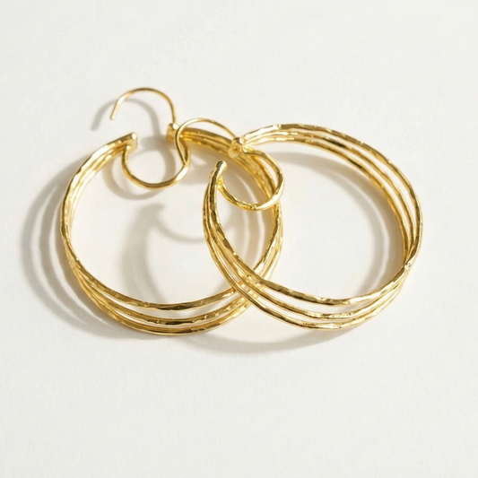 Gold hoop earrings on a light gray background