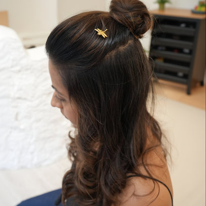 Woman with hair styled in a bun with a hair clip, blurred background