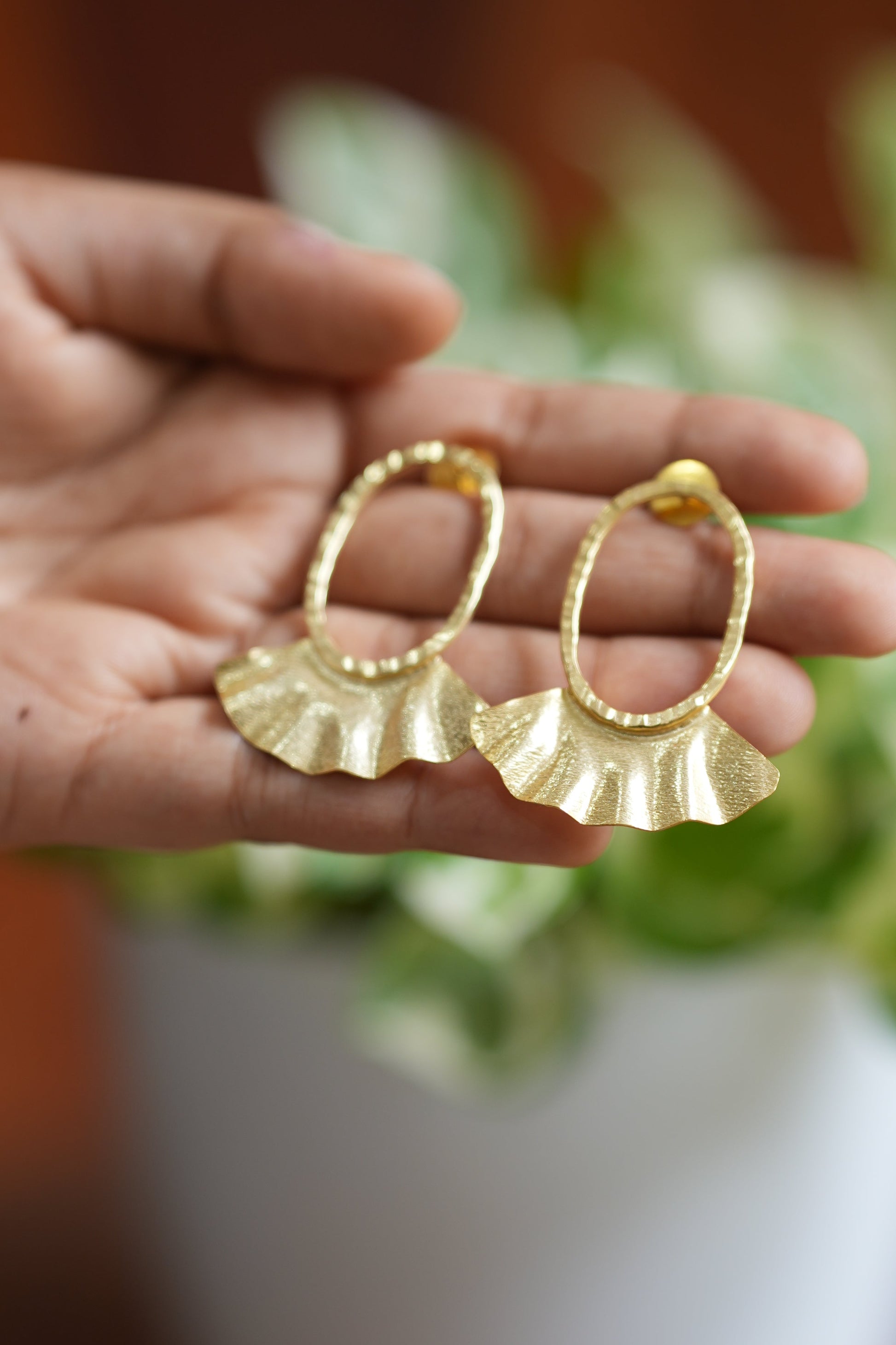 Gold earrings held in a hand 