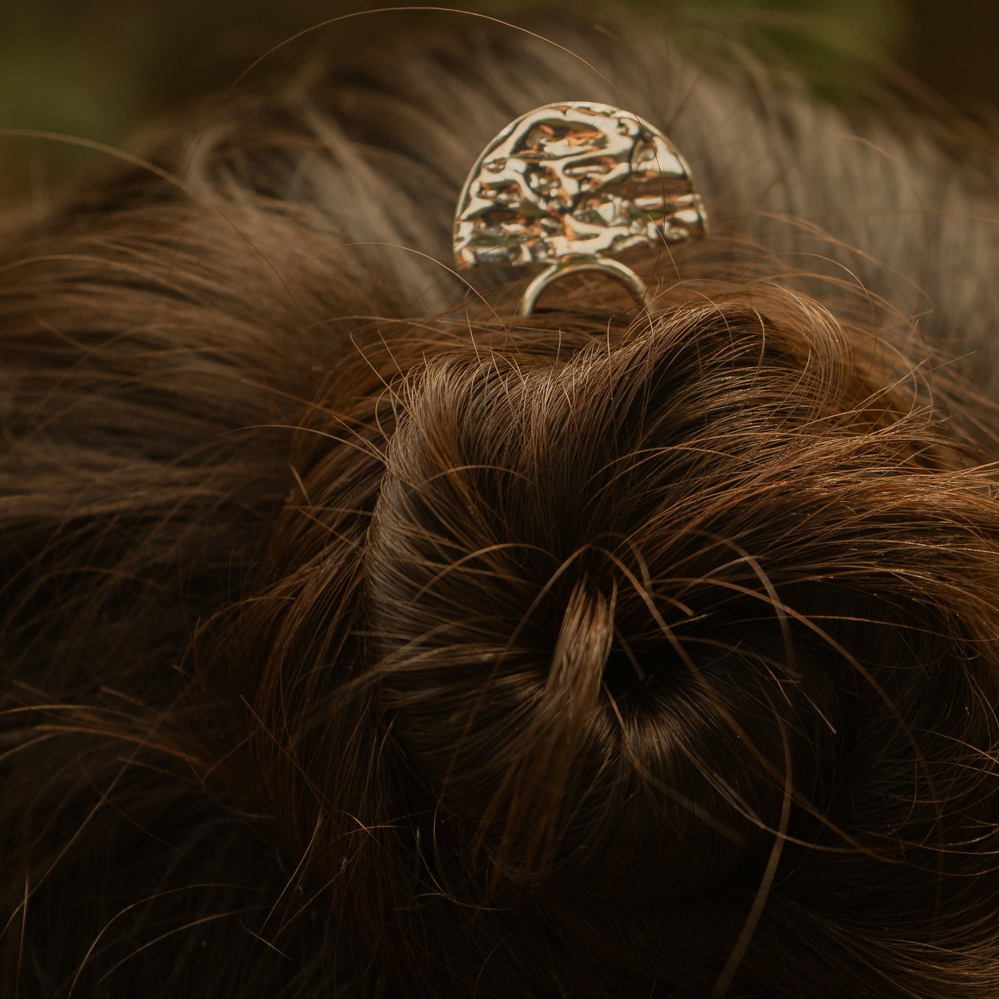Close-up of a hair bun with a decorative hair clip against a blurred background