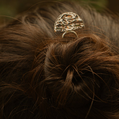 Close-up of a hair bun with a decorative hair clip against a blurred background