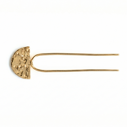 Gold hairpin with textured half-circle design on a white background