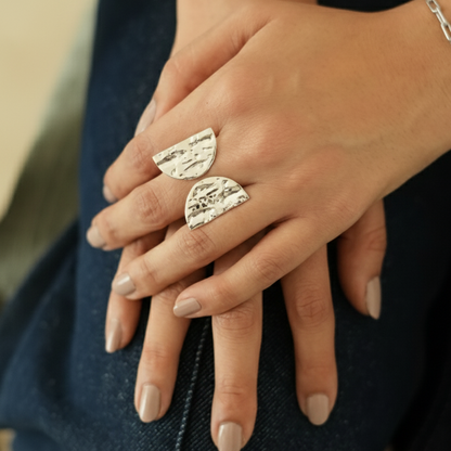 Close-up of hands with silver ring on a blurred background