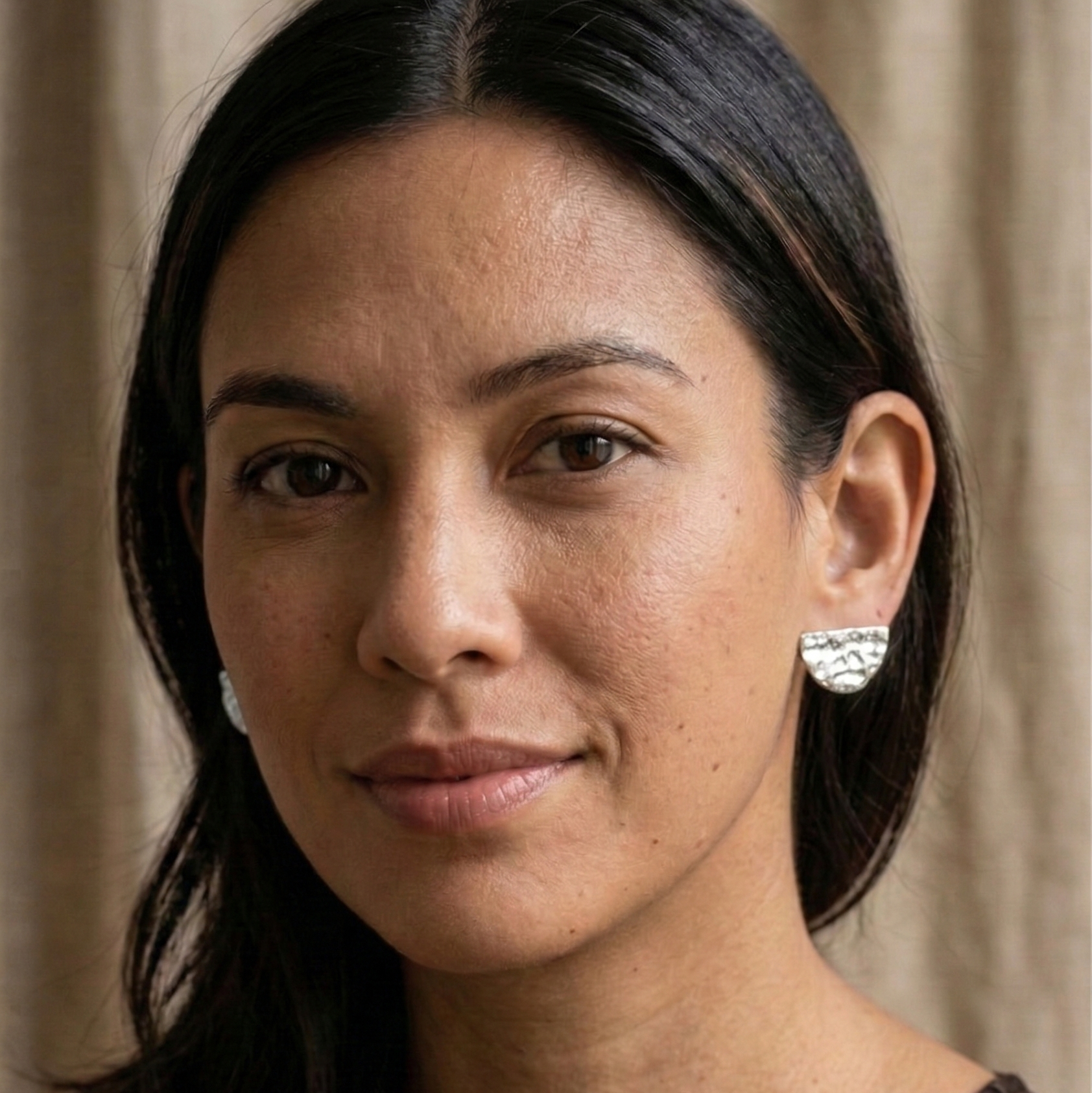 Woman wearing earrings with a neutral background