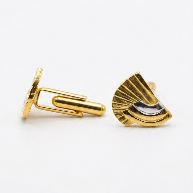 A pair of gold cufflinks on a clean white background, one showing the side profile with its butterfly clasp and the other showing the front face with a fan-like segmented design and a small black accent.