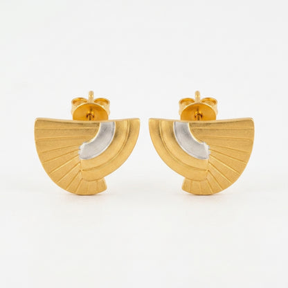 A pair of gold fan-shaped stud earrings with a polished silver crescent inlay, shown against a plain white background.