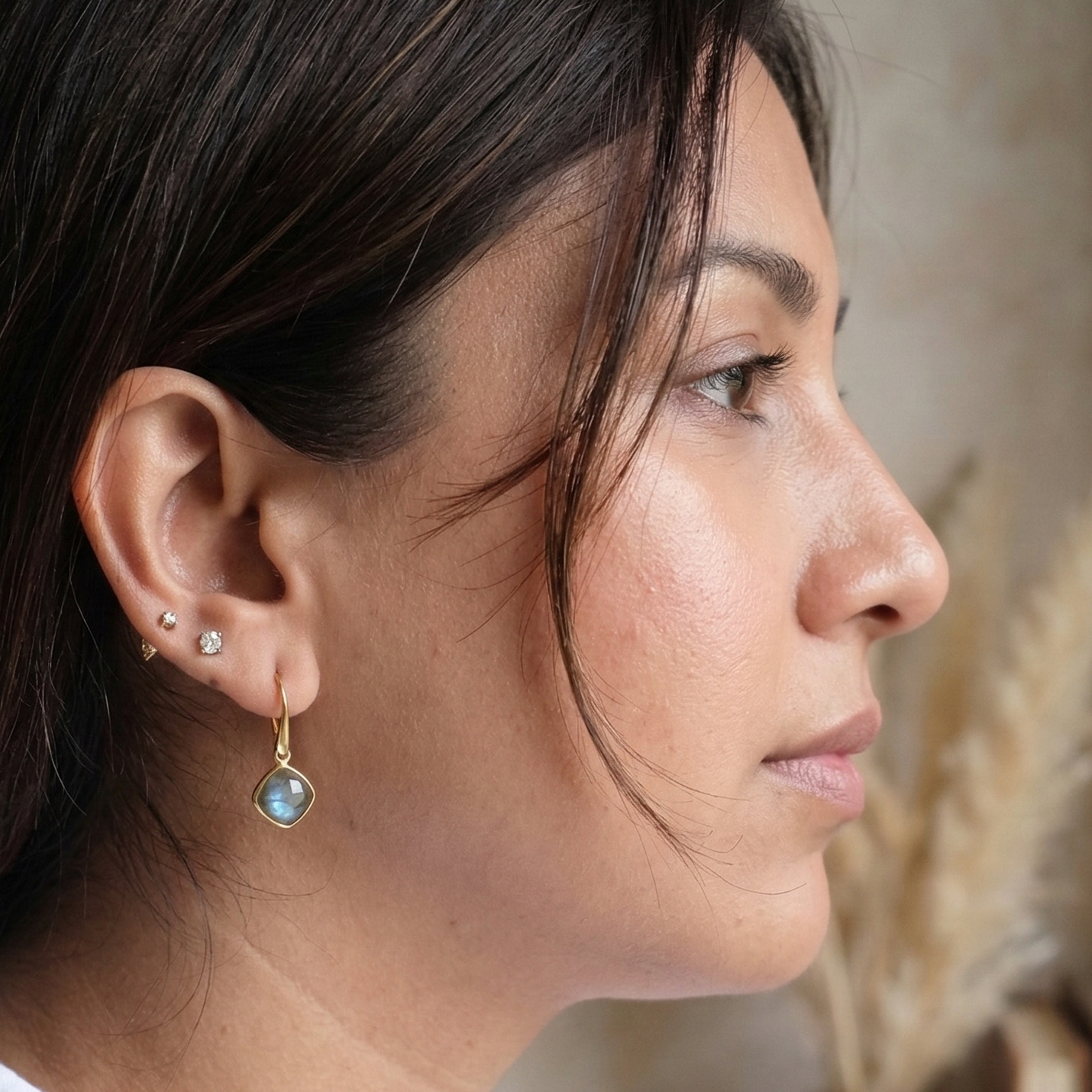 Woman wearing earrings with a neutral background