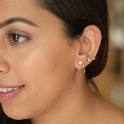 Close-up of a woman wearing gold earrings with a blurred background