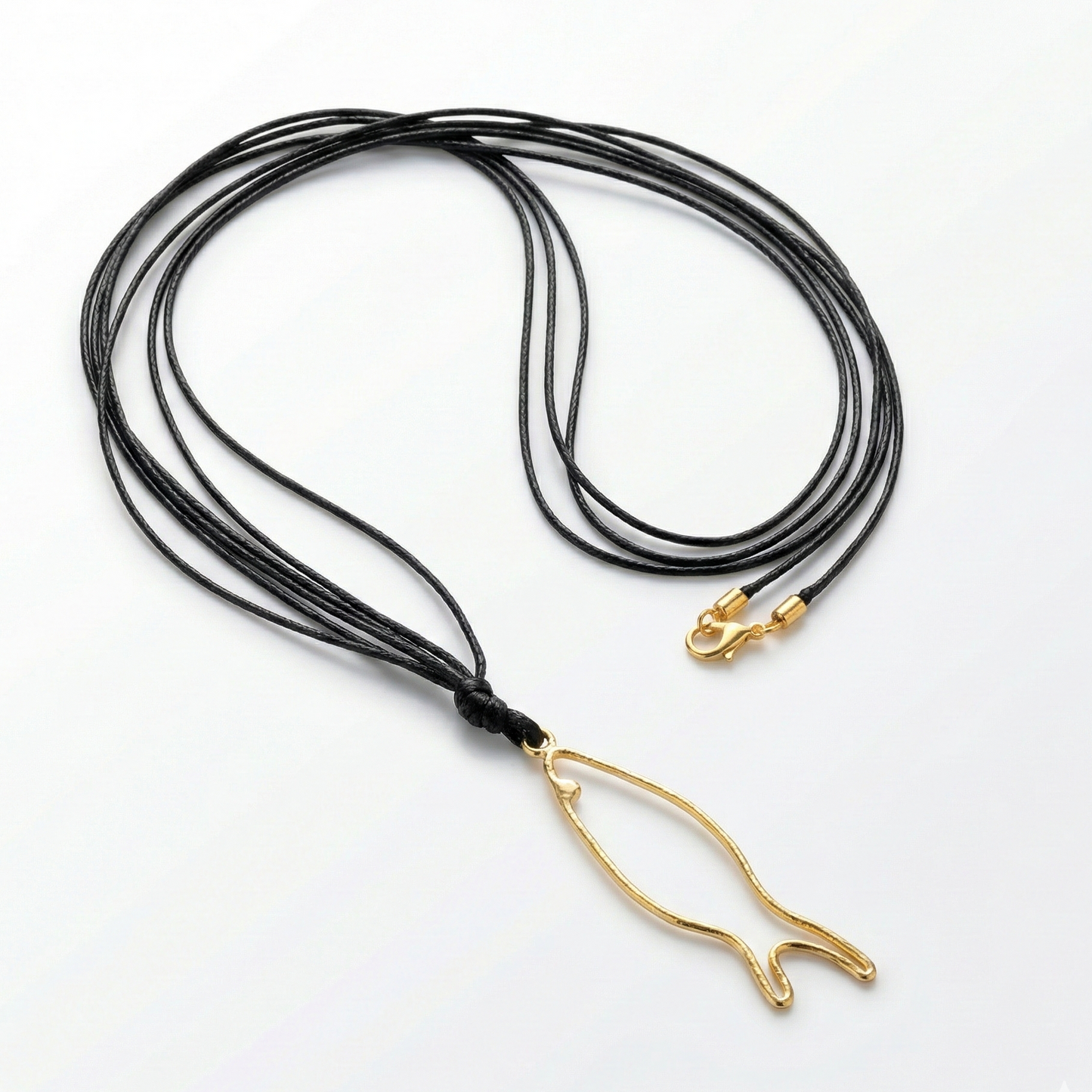 Black cord necklace with a gold fish-shaped pendant on a white background