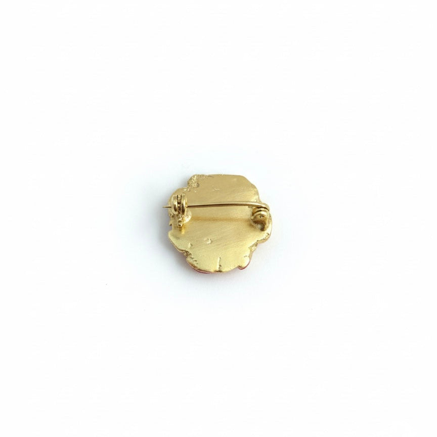 Gold-plated brooch on a white background