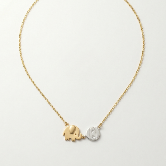 Gold and silver elephant pendant necklace on a light gray background