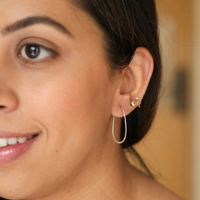 Close-up of a woman wearing hoop earrings with a blurred background