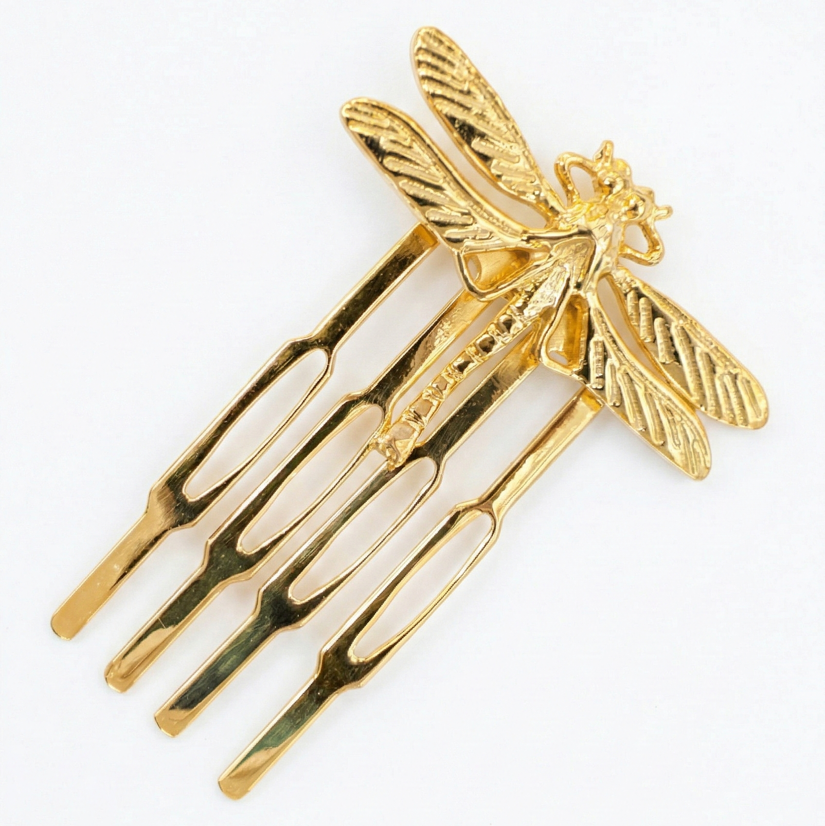 Gold hair comb with dragonfly design on a white background