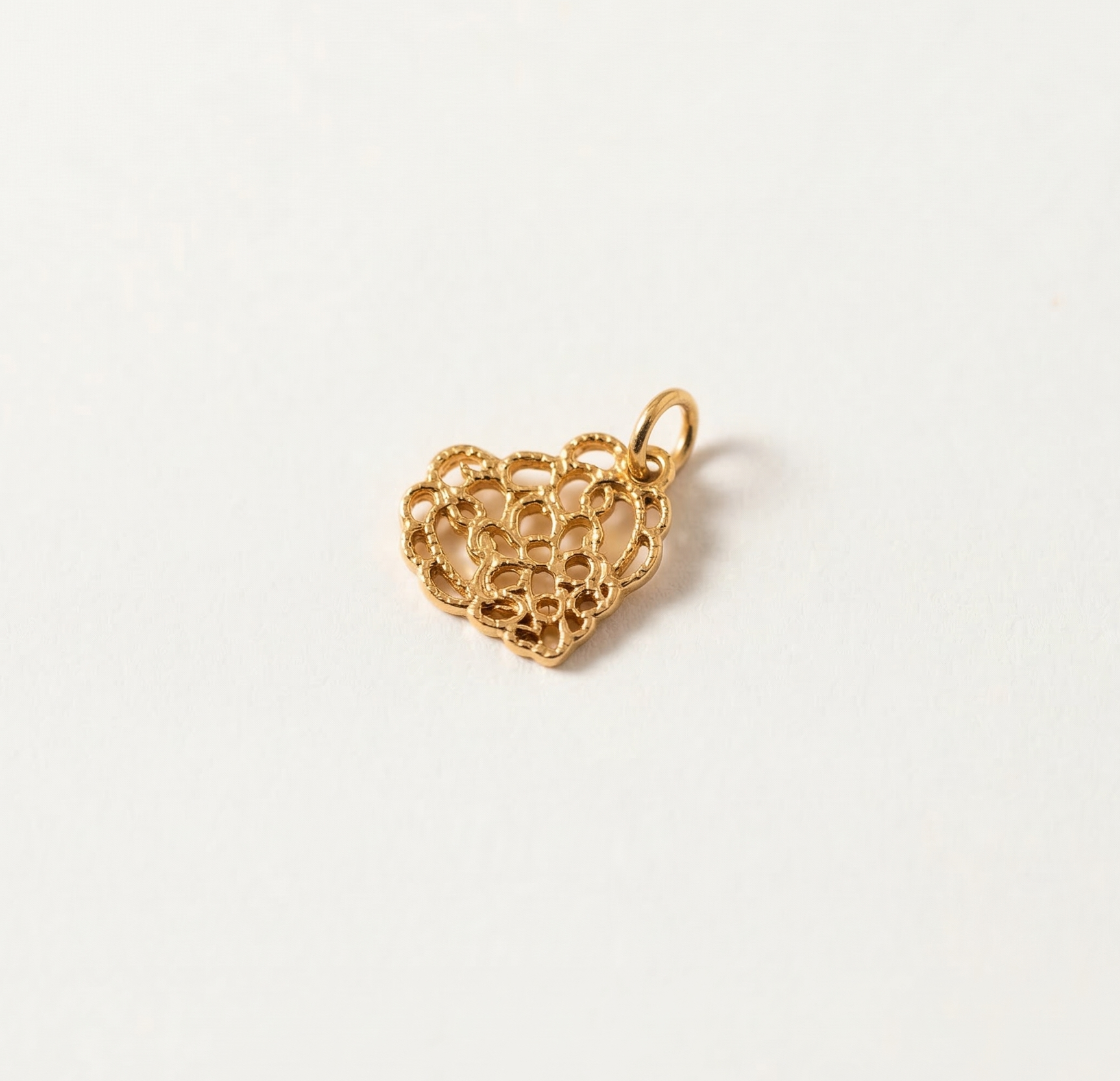 Gold heart-shaped pendant on a white background