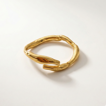 Gold ring with a textured design on a light gray background