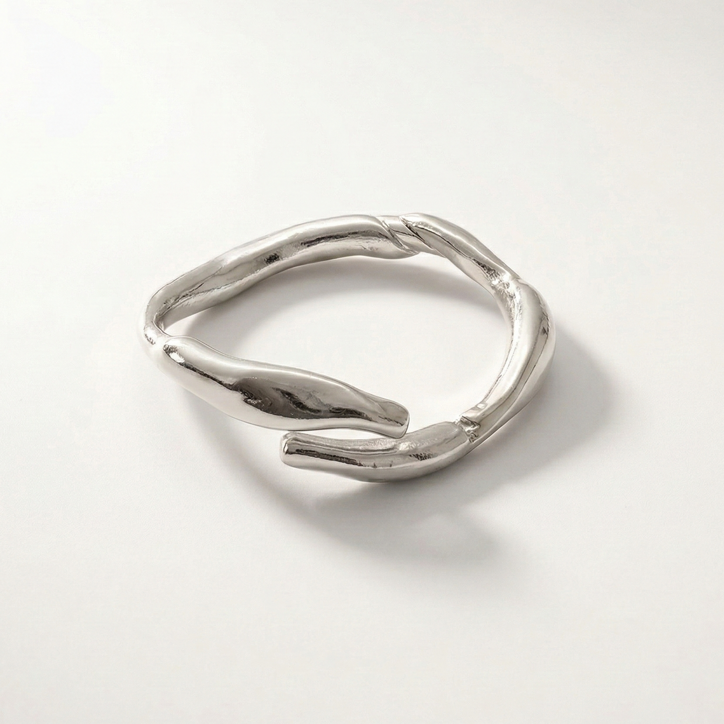 Silver ring with a unique design on a light gray background